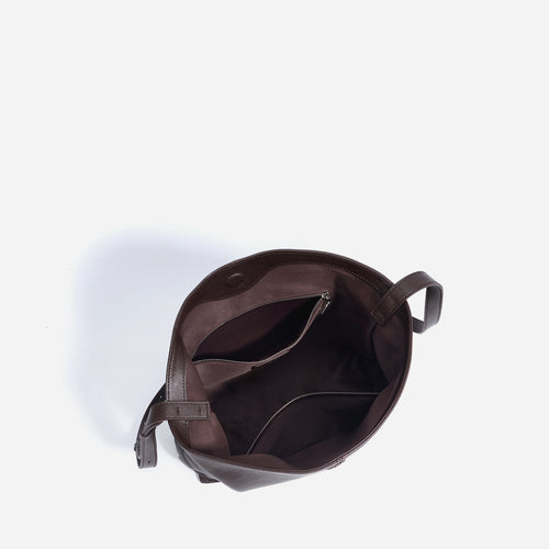Top-down view of a dark brown leather tote bag interior with pockets and straps.