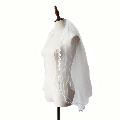 White tulle wedding veil with double leaf embroidery edging, displayed on a mannequin.