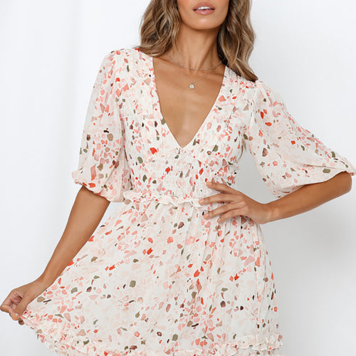 Model wearing a cream chiffon mini dress with V-neck, half puff sleeves, and colorful abstract terrazzo print.