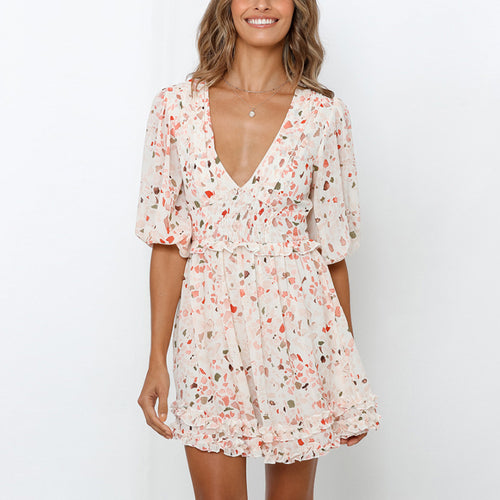 A short beige chiffon dress with V-neck, half puff sleeves, and colorful abstract print.