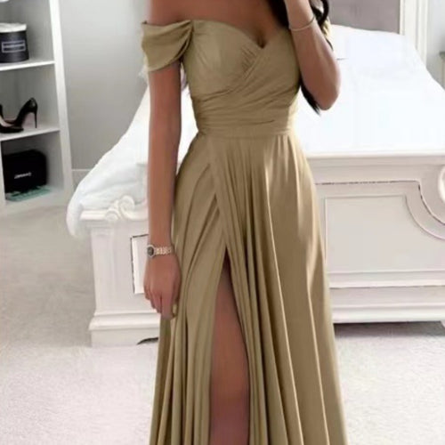 A person wearing a long, gold off-the-shoulder dress with a sweetheart neckline and a high slit.