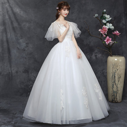 A white plus-size wedding dress with sheer ruffled sleeves, V-neckline, and a full A-line tulle skirt.