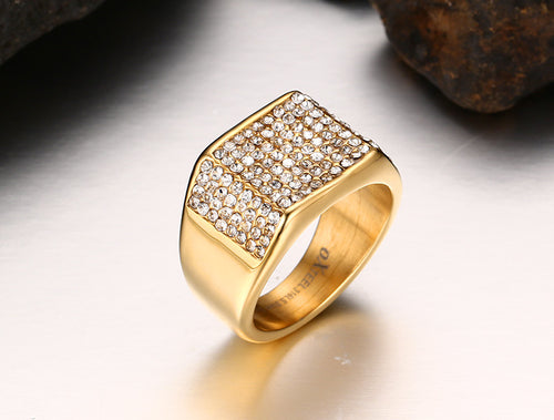 Gold-colored titanium steel ring with a wide, flat top face pavé-set with clear stones.