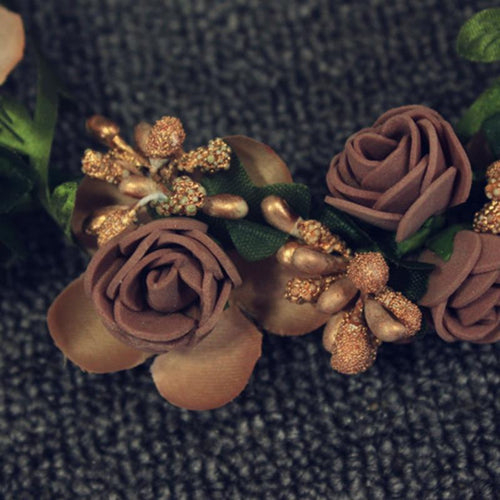 Brown silk flower crown featuring roses, petals, green leaves, and gold glittery berries.