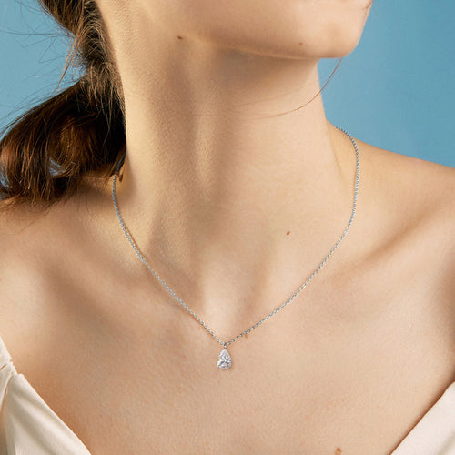 A sterling silver necklace with a teardrop-shaped pendant worn on a person.