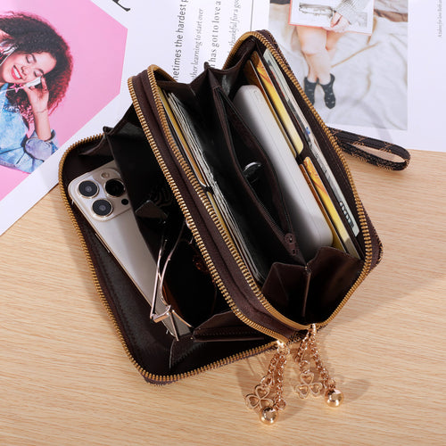 Open brown leather double-zipper wallet holding a smartphone, glasses, cards, and cash.