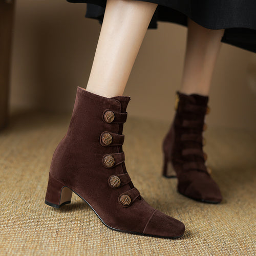 Brown suede ankle boots with a chunky heel and decorative crystal buttons on side straps.